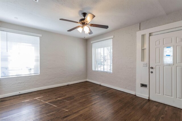 foyer featuring a textured ceiling, dark hardwood / wood-style flooring, and ceiling fan