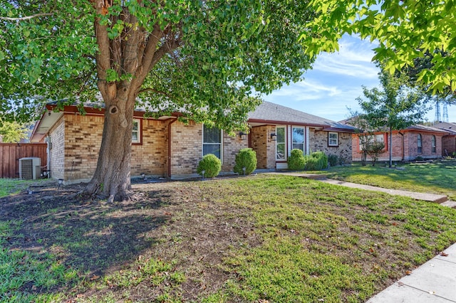 single story home with cooling unit and a front yard