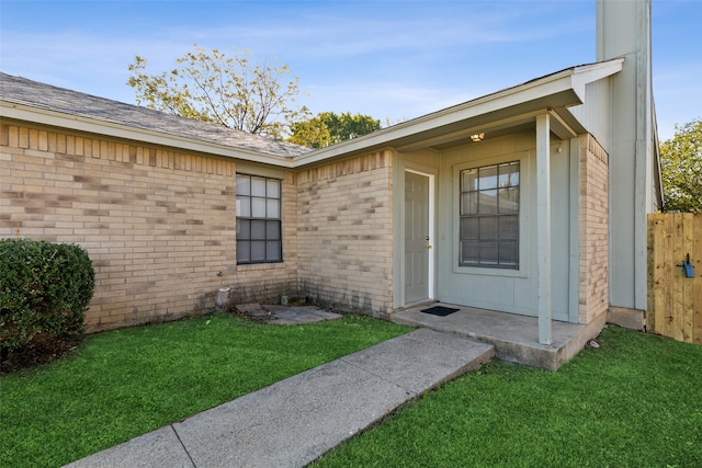 view of exterior entry with a yard