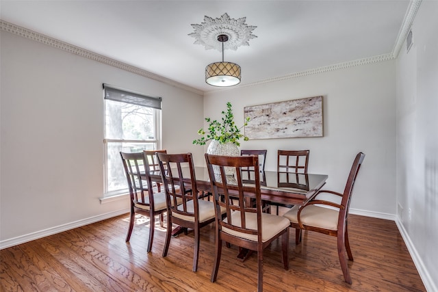 dining space featuring hardwood / wood-style flooring and crown molding