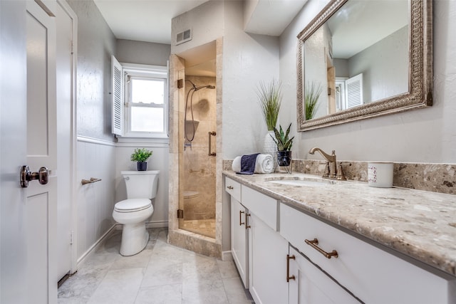 bathroom featuring vanity, toilet, a shower with shower door, and tile patterned flooring