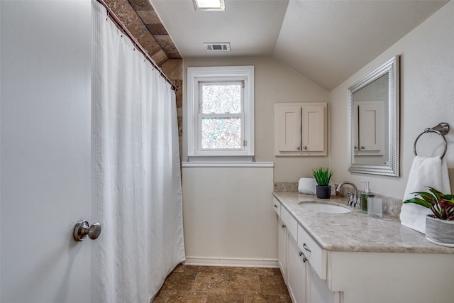 bathroom with vanity and lofted ceiling