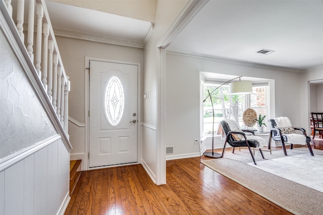 entryway featuring ornamental molding, a wealth of natural light, and hardwood / wood-style flooring