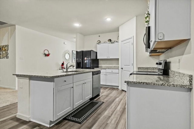 kitchen featuring hardwood / wood-style floors, white cabinets, a kitchen island with sink, and stainless steel appliances