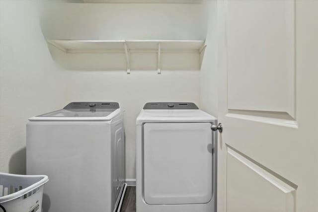 laundry room with washing machine and clothes dryer and wood-type flooring