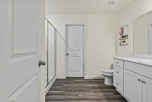 bathroom featuring vanity, an enclosed shower, toilet, and wood-type flooring