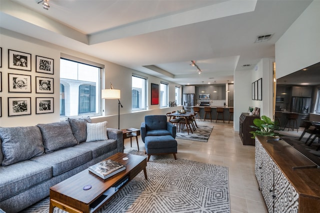 tiled living room featuring a raised ceiling