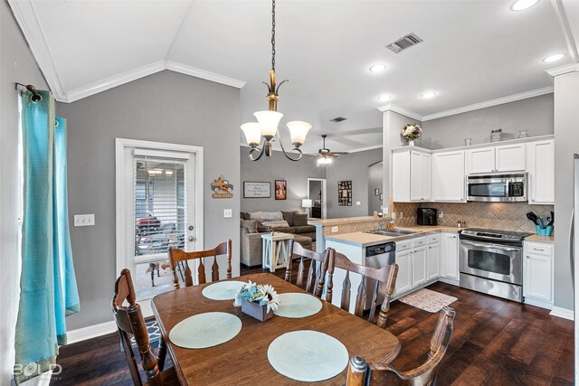 dining area with lofted ceiling, dark hardwood / wood-style flooring, ornamental molding, and sink