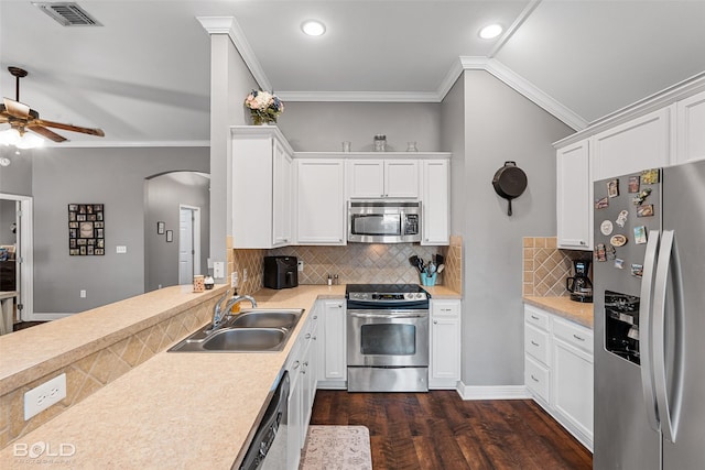 kitchen featuring dark wood-type flooring, crown molding, sink, white cabinetry, and stainless steel appliances