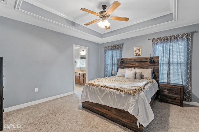 carpeted bedroom with a raised ceiling, multiple windows, and ceiling fan