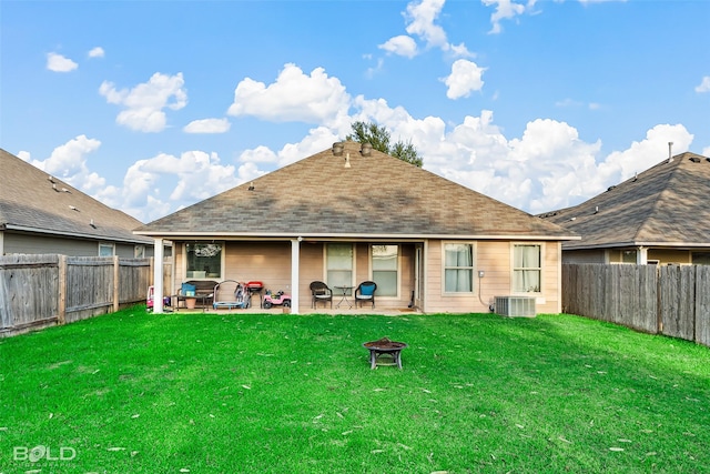 rear view of house featuring a lawn, cooling unit, a patio, and an outdoor living space with a fire pit