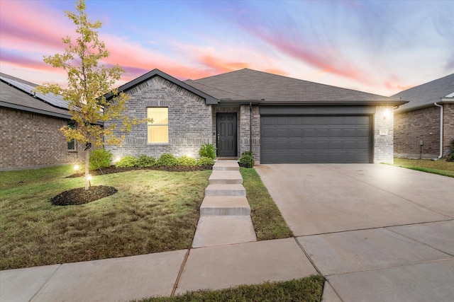 view of front facade with a yard and a garage