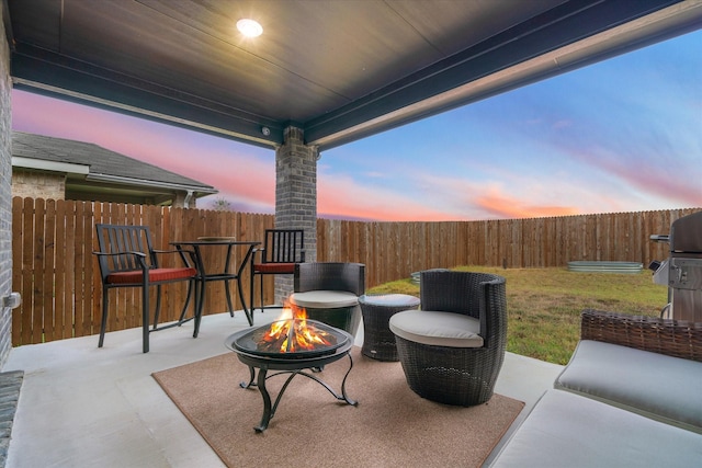 patio terrace at dusk with a yard and a fire pit