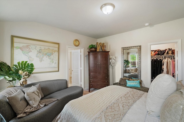 bedroom with ensuite bath, a spacious closet, and a closet