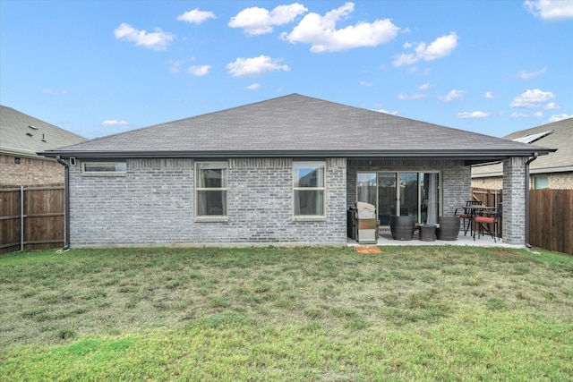 back of house with a yard and a patio