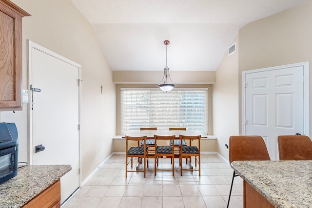 dining room with light tile patterned flooring and lofted ceiling