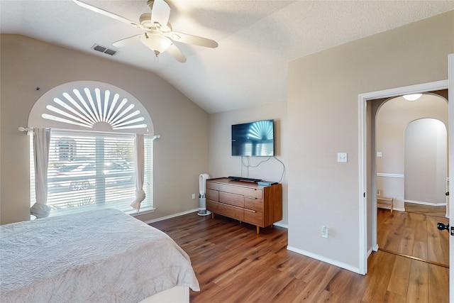 bedroom with a textured ceiling, ceiling fan, hardwood / wood-style floors, and lofted ceiling