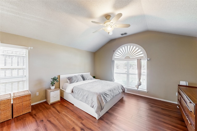 bedroom featuring hardwood / wood-style floors, ceiling fan, and multiple windows