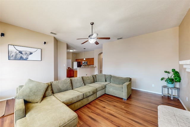 living room featuring a fireplace, hardwood / wood-style floors, and ceiling fan