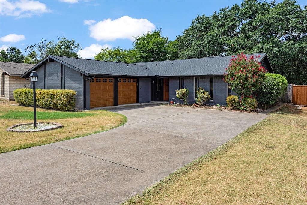 ranch-style house with a front yard and a garage