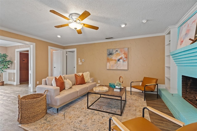 living room featuring a fireplace, ornamental molding, hardwood / wood-style flooring, and a textured ceiling