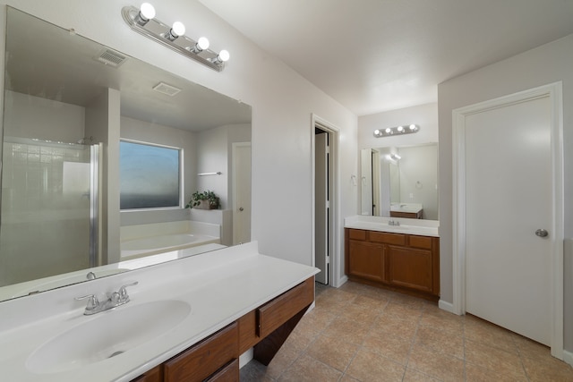 bathroom with tile patterned floors, vanity, and shower with separate bathtub