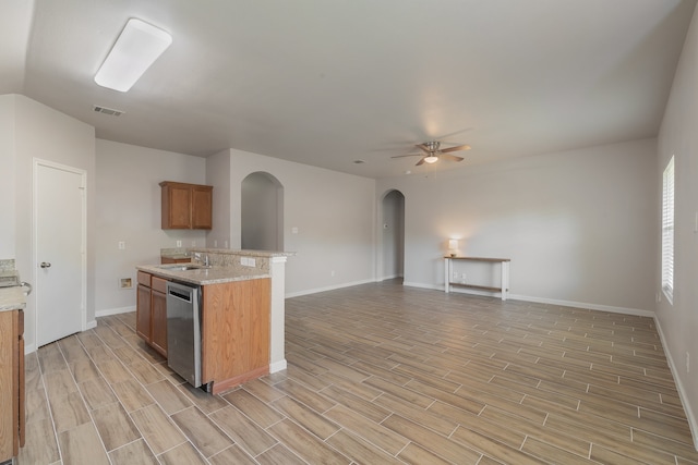 kitchen featuring light wood-type flooring, light stone counters, ceiling fan, sink, and dishwasher