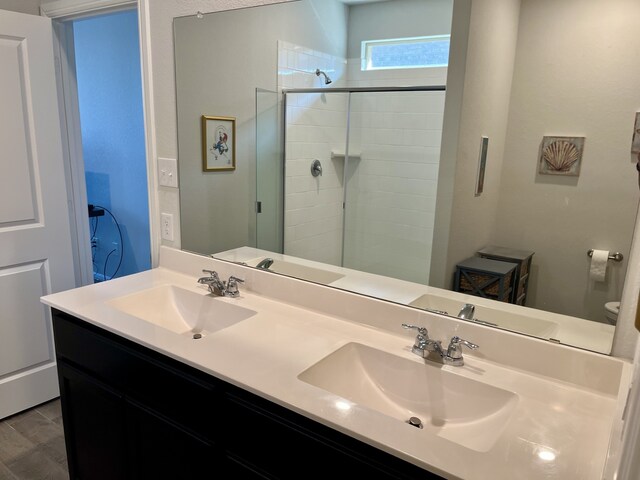 bathroom with hardwood / wood-style floors, vanity, and walk in shower