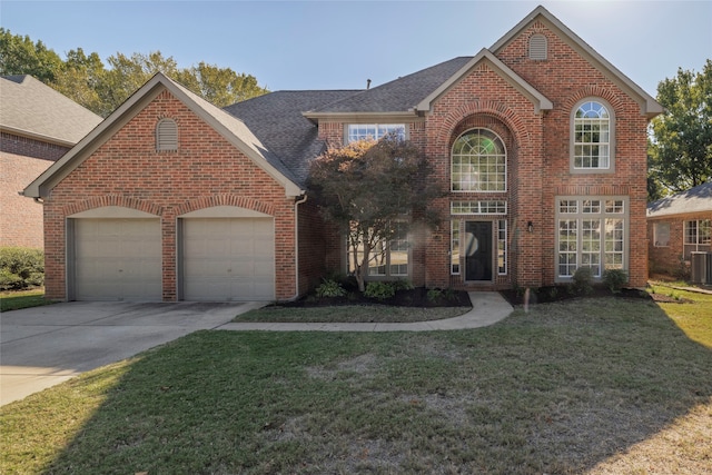 view of front property featuring a front lawn, central AC unit, and a garage