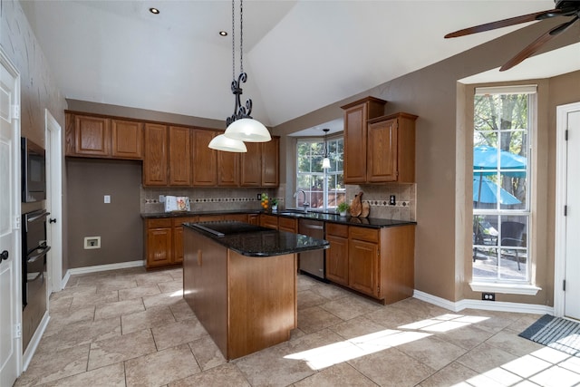 kitchen featuring appliances with stainless steel finishes, a center island, a healthy amount of sunlight, and sink