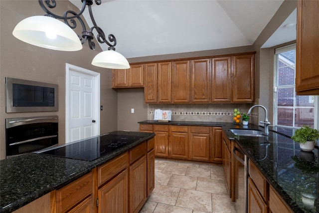 kitchen featuring backsplash, stainless steel appliances, sink, dark stone countertops, and hanging light fixtures