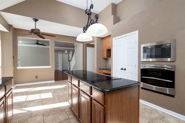 kitchen with hanging light fixtures, light tile patterned floors, dark stone countertops, a kitchen island, and appliances with stainless steel finishes