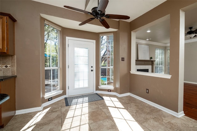 entryway with ceiling fan, light hardwood / wood-style flooring, and crown molding