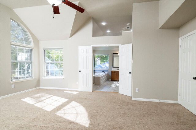 unfurnished bedroom with light carpet, ensuite bathroom, and multiple windows