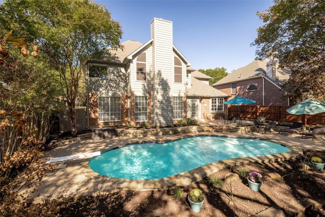 view of swimming pool featuring a diving board and a patio area