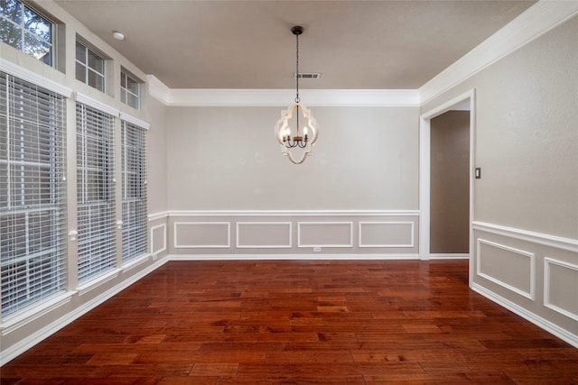 unfurnished dining area with a chandelier, ornamental molding, and dark wood-type flooring