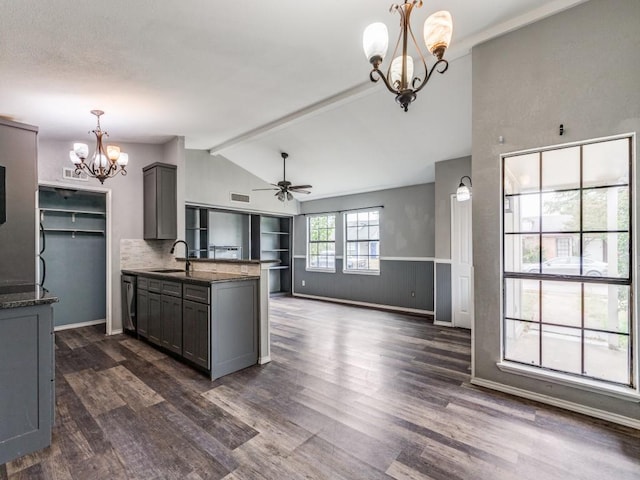 kitchen featuring gray cabinetry, sink, dark stone counters, and decorative light fixtures