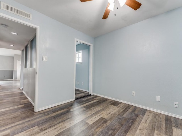 unfurnished room with ceiling fan and dark wood-type flooring