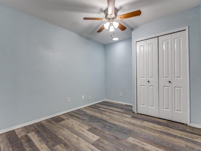 unfurnished bedroom featuring a closet, ceiling fan, and dark hardwood / wood-style flooring