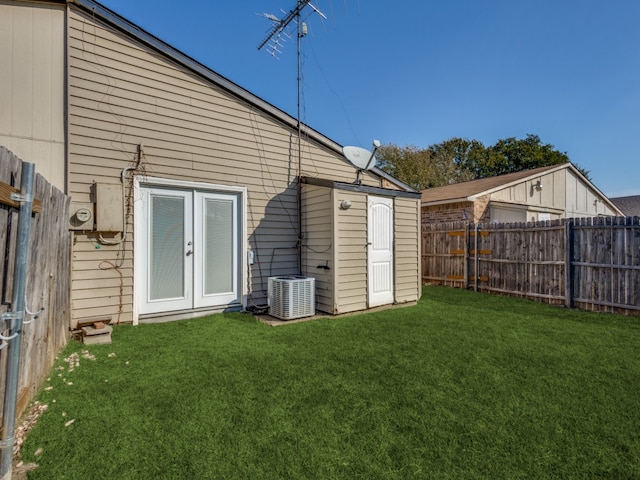 rear view of property featuring central AC, a yard, and french doors