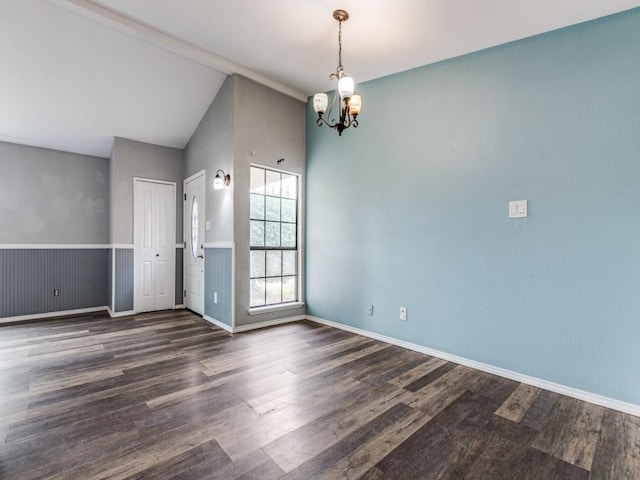 unfurnished room featuring a chandelier, vaulted ceiling, and dark wood-type flooring