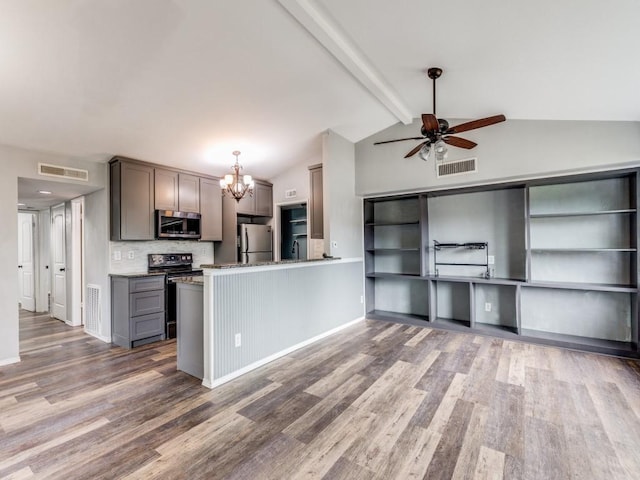 kitchen with vaulted ceiling with beams, wood-type flooring, kitchen peninsula, and stainless steel appliances