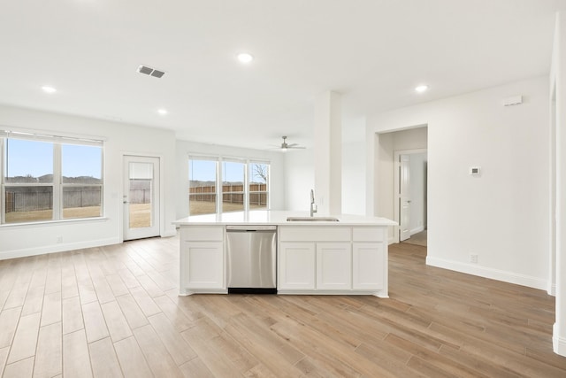 kitchen featuring stainless steel dishwasher, light hardwood / wood-style flooring, sink, and white cabinets