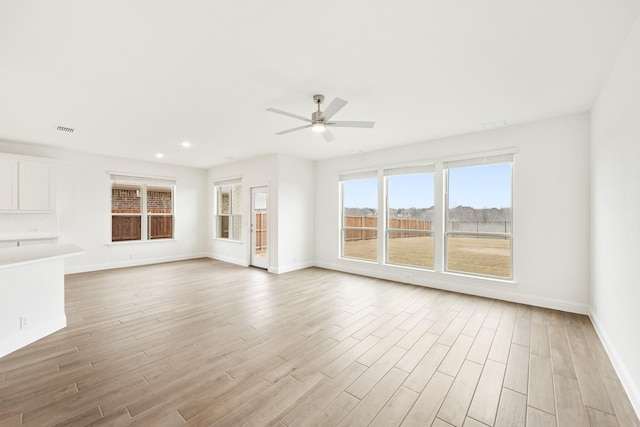 unfurnished living room featuring ceiling fan and light wood-type flooring