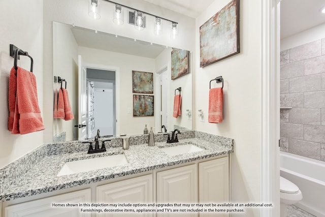 full bathroom featuring vanity, tiled shower / bath combo, and toilet