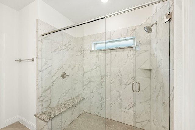 bathroom featuring a shower with door