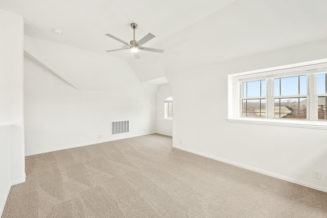 interior space with light carpet, vaulted ceiling, and ceiling fan