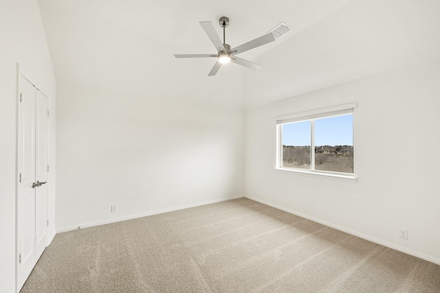 spare room with vaulted ceiling, carpet flooring, and ceiling fan