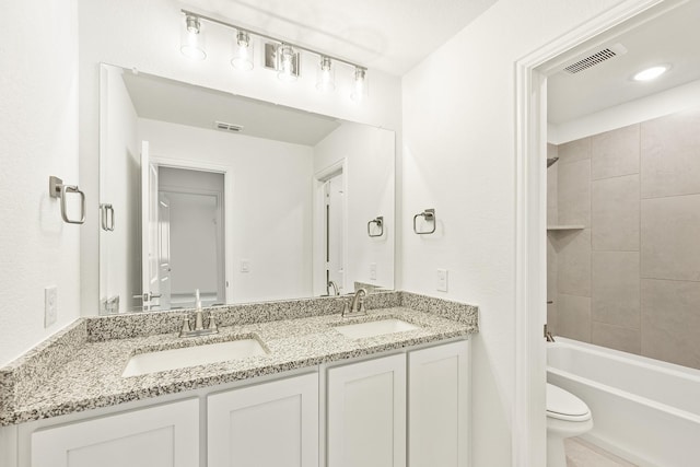 full bathroom featuring toilet, vanity, and tiled shower / bath combo