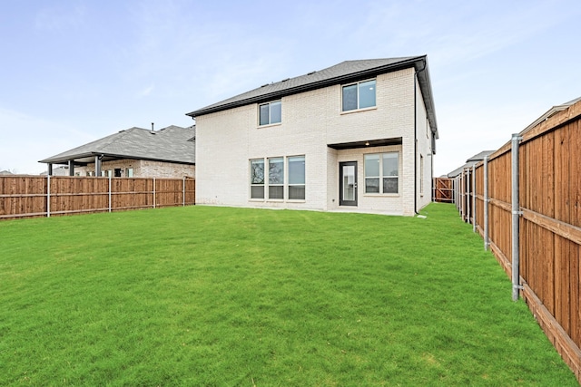 rear view of property featuring a lawn